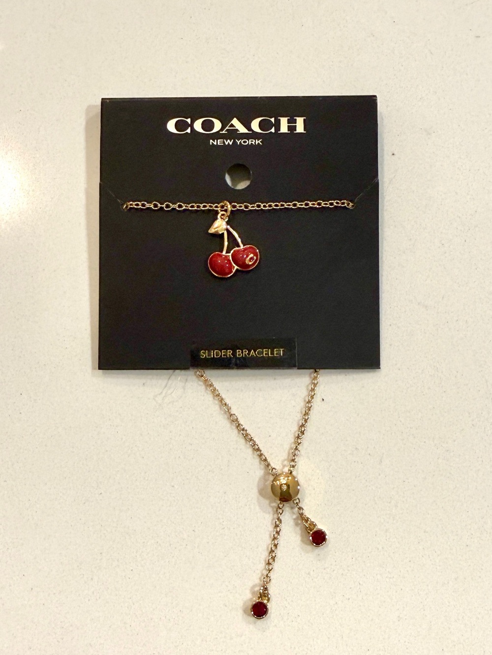 Coach Gold-Tone Slider Bracelet with Red Cherry Enamel Charm
